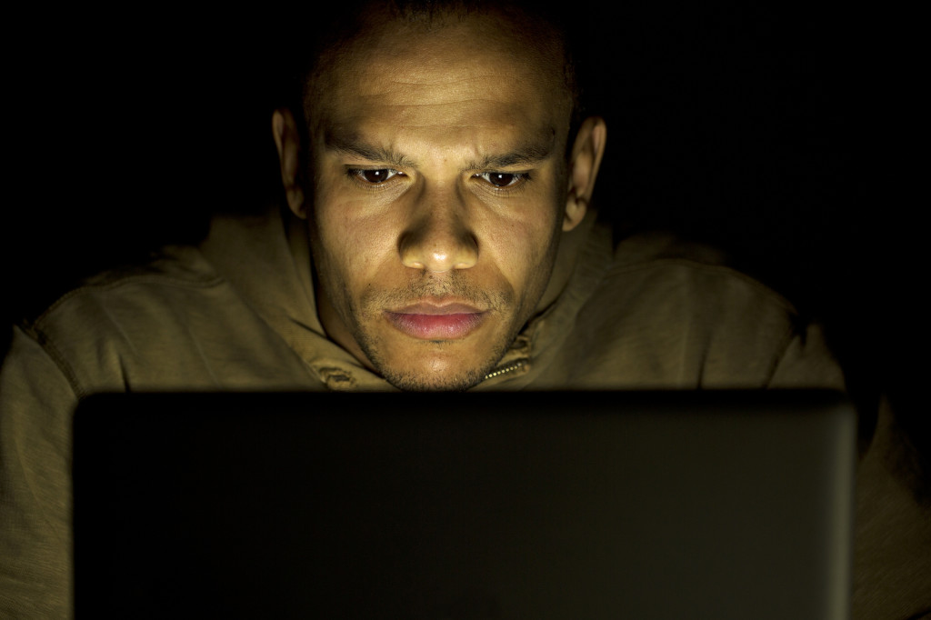 Man concentrating on his laptop at night